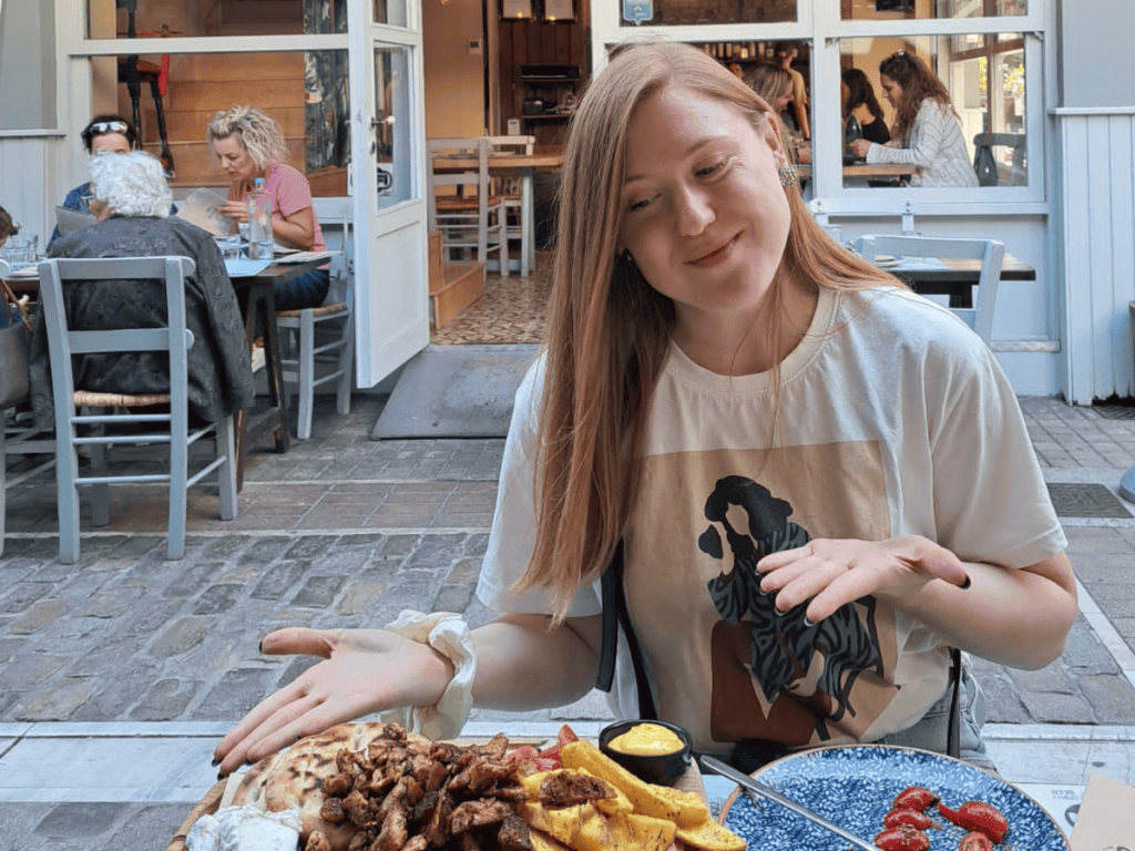 Girl at a vegan restaurant Roots in Solun in Greece looking at a vegan gyros.