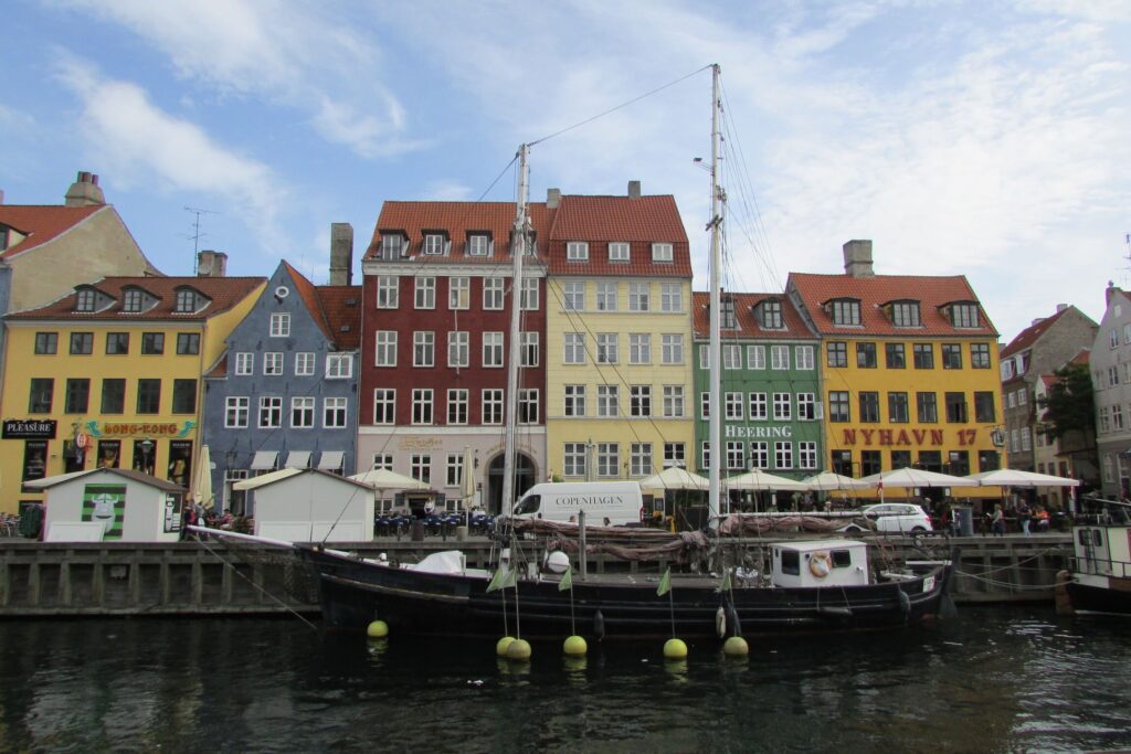 Zelena, crvena, plava i žute kuće s bijelim i drvenim prozorima pokraj Nyhavn kanala u Kopenhagenu u Danskoj.