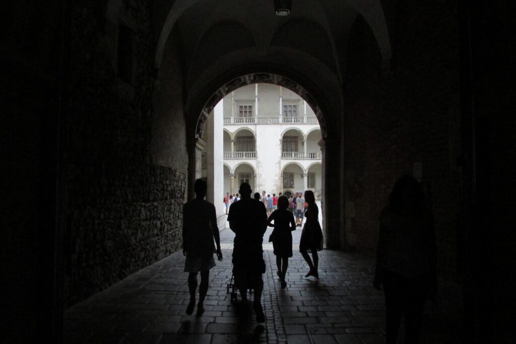Tunel u sjeni sa siluetama ljudi u dvorcu Wawel, Krakow, Poljska.