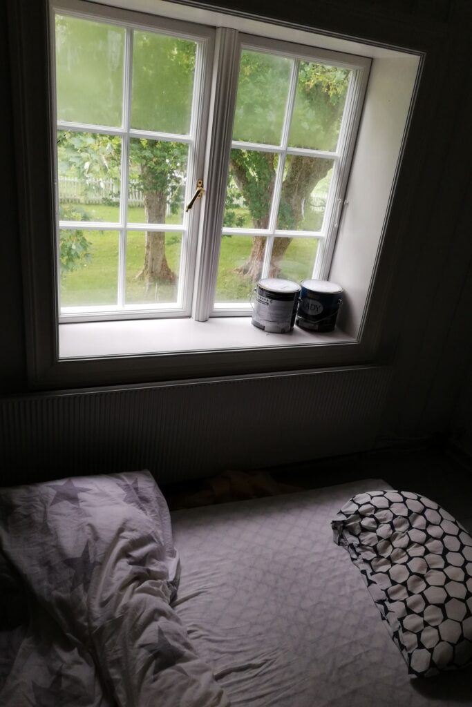 Madrac na podu ispod prozora sa zvjezdanom posteljinom.
