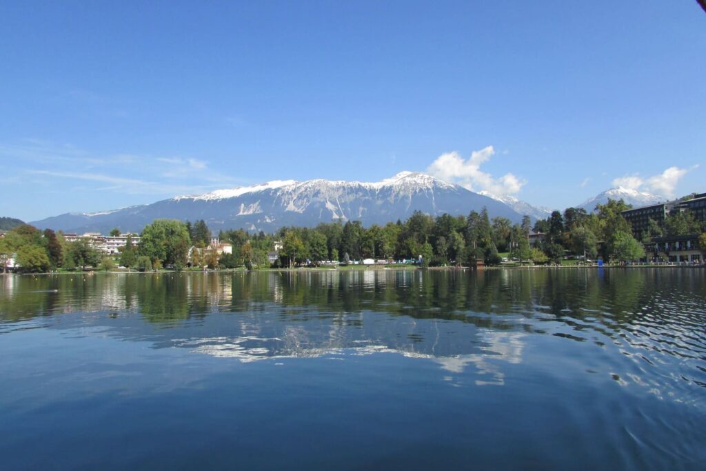 Odraz planine Triglav sa snježnim vrhom u vodi jezera Bled u Sloveniji.